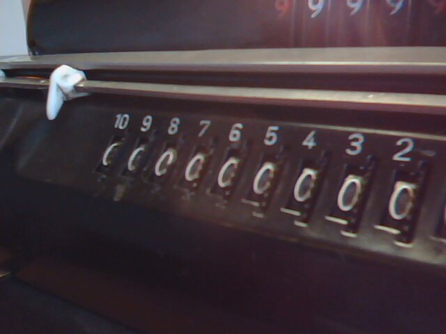 Detail výsledkového registru - vedle každé cifry je ozubené kolo, které umožní libovolně přenastavit hodnotu této cifry